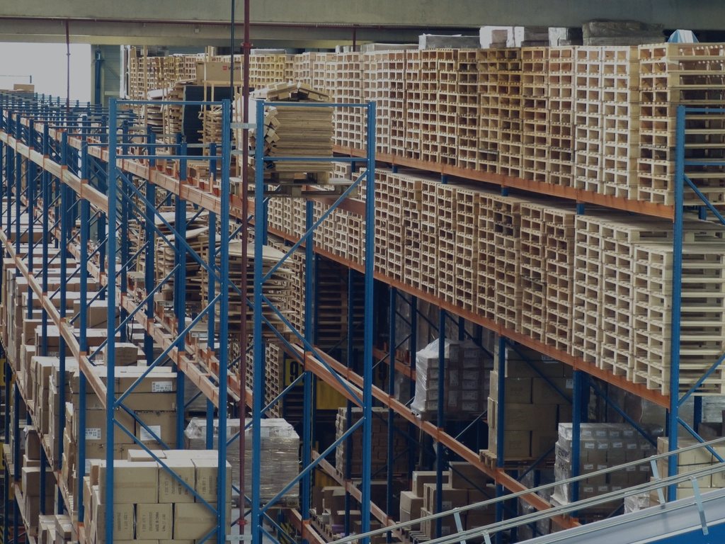 Depo koridorunda istiflenmiş paletler — servis robotunun çalıştığı endüstriyel zemin